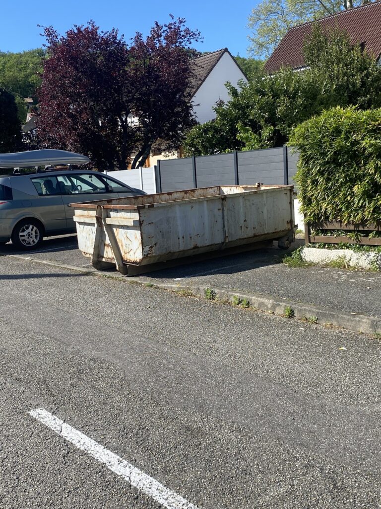 Benne Guerdner posée sur une place de stationnement le long de la rue, devant une maison