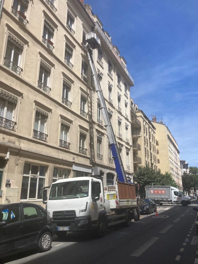 Camion benne de Sony Guerdner garé dans une rue de Lyon devant un immeuble en travaux