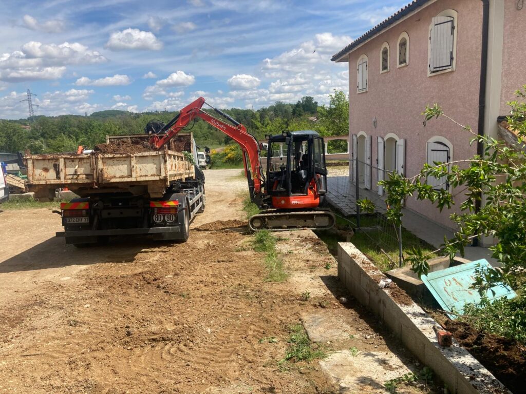Mini-pelle qui charge un camion benne sur un chantier de Sony Guerdner dans le Rhône